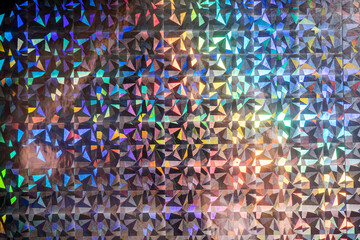 macro photo of silver rainbow holographic foil, colorful hologram surface, glitter grid pattern background.