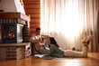 © New Africa - Lovely couple with delicious cocoa near fireplace on floor at home. Winter vacation