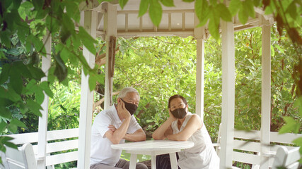 Wall Mural - Asian elder senior couple wear mask quarantine eascape in green natural park background happy in nature
