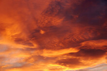 Dark Blood Red Sky Background. Dramatic Heavy Clouds With The Hint Of The Sun At Sunset. Many Orange Tones And Patterns Of Clouds.