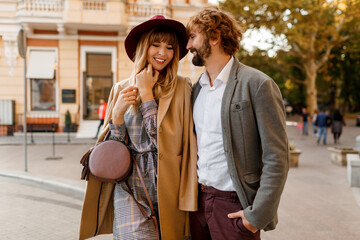 Close up portrait of amazing stylish couple in love  spending  romantic holidays in European city. Pretty blond woman in hat and casual dress smiling and looking on her handsome man with beard.