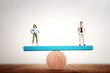 © tomertu - Concept image of gender equality. man and woman balancing on seesaw