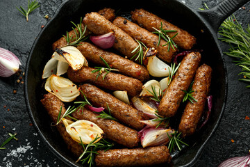 Wall Mural - Rosemary and onion vegetarian vegan sausages oven baked in cast iron skillet frying pan