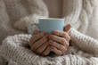 © fizkes - Close up mature woman wrapped warm blanket holding mug of coffee or tea, middle aged female enjoying free time, weekend at home, relaxing, drinking hot beverage in morning, starting new day
