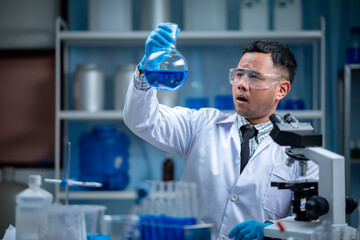 Wall Mural - the special young male scientis or reseacher looking the chemical solution through the test tube for