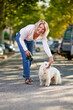 © JENOCHE - Elderly woman walking with a dog outdoors