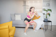 © Parilov - Fitness woman in athletic workout clothes training indoor home, uses stretching for trainer online. Interior room modern
