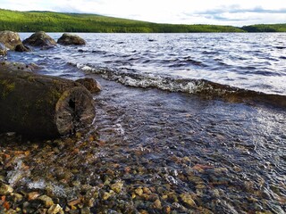 Large stones rocks on the lake shore at sunset