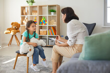 Little Girl Sharing Her Concerns With Supportive Child Psychologist During Therapy Session In