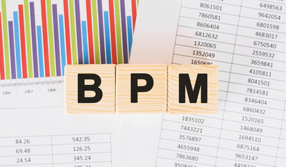 Poster - bpm word written on wood block. faqs text on table, concept.