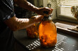 A woman rolls a compote in a large jar under the sun in summer at home in the village.