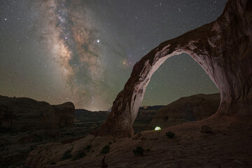 camping tent underneath corona arch and the milky way galaxy