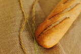 Fototapeta Kuchnia - French baguette on sackcloth material, fresh bread on burlap