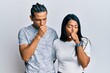 © Krakenimages.com - Young latin couple wearing casual clothes feeling unwell and coughing as symptom for cold or bronchitis. health care concept.