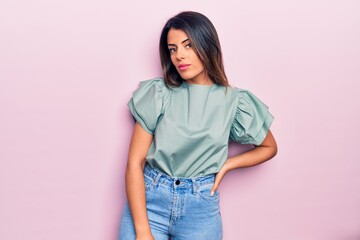 Young beautiful brunette woman wearing casual clothes standing over isolated pink background