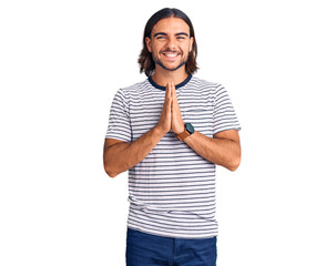 Young handsome man wearing casual clothes praying with hands together asking for forgiveness smiling confident.