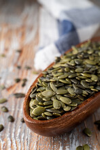 Peeled Pumpkin Seeds In A Wooden Bowl On A Light Rustic Wooden Table, Close Up, Selective Focus, Catalogue Photo