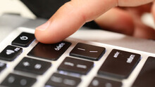 Think Before Posting.  Close Up Of A Finger About To Push The Delete Key On A Computer Keyboard. Online Cyber Bullying Social Media Trolling Abuse Concept. Deleting History, Cancel Culture Concept