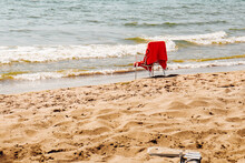 Seascape Beach Scene: White Empty Chair With Red Towel Standing By The Sea On Sunny Summer Day.