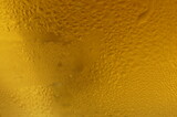 Wet glass of beer, golden color in the dark