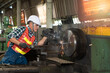 © godji10 - Male worker working on a lathe machine in metal industry factory on a business day. Professional engineer wearing a hard hat and safety glasses operating CNC milling machine in manufacturing workshop