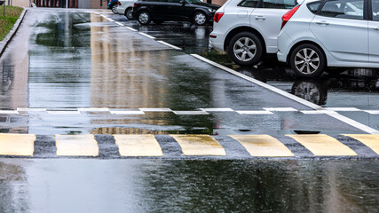 Wall Mural - parking lot on side of city street with cars and wet asphalt after rain