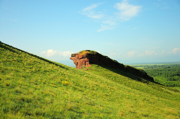 Wall Mural - Remains of an ancient wall on top of a high grassy hill.