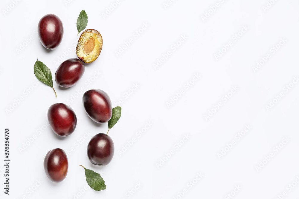 Tasty sweet plums on white background