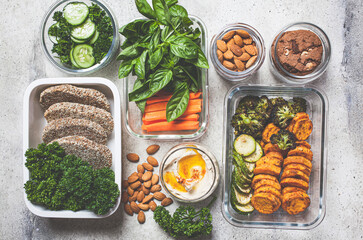 Canvas Print - Preparing healthy meals for the week, top view. Vegan food and healthy snacks in containers, gray background.