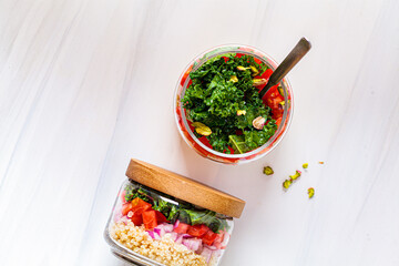 Wall Mural - Vegan salad with vegetables and quinoa in glass jars, white background, copy space, top view.