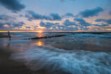 Fototapeta Pomosty - Sea landscape at sunset. Beach, sea waves, breakwaters.