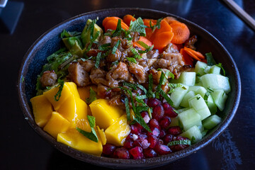 Asian food concept. Poke bowl of fried rice with meat, fresh fruits and vegetables. 