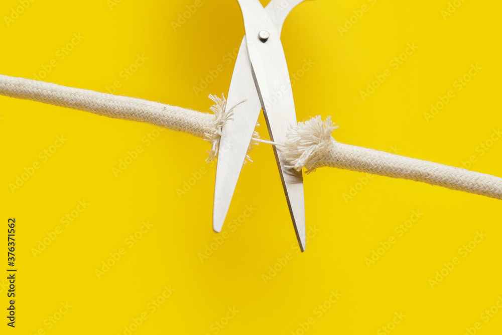 Scissors with frayed rope on color background Stock Photo | Adobe Stock