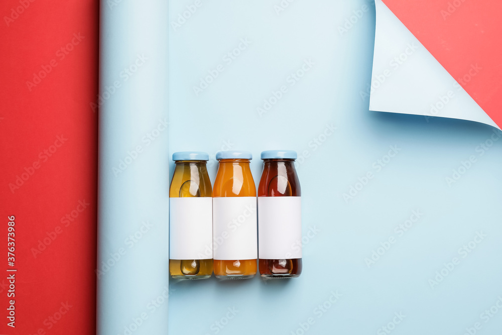 Bottles of juices on color background
