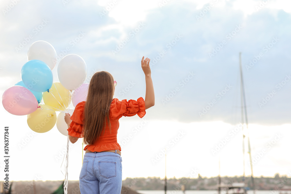 Young woman with balloons outdoors