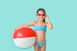 © Pixel-Shot - Little girl in swimsuit and with ball on color background