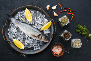 Wall Mural - Raw seabass fish on wooden background