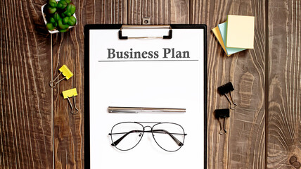 Poster - business plan form on a wooden table.