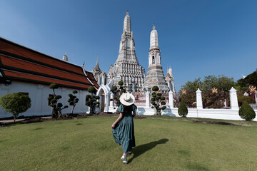 Wall Mural - Young Asian woman is enjoy sightseeing and traveling at Wat Arun temple in Bangkok, Thailand.