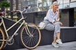 © Svitlana - Pretty woman in white business clothes with bike in the city