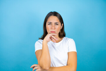 Young beautiful woman over isolated blue background thinking looking tired and bored with crossed arms