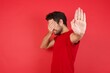 © Roquillo - Young handsome caucasian man wearing t-shirt over isolated red background covers eyes with palm and doing stop gesture, tries to hide from everybody. People, body language.