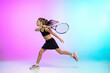 © master1305 - Unstoppable. Little tennis girl in black sportwear isolated on gradient background in neon light. Little caucasian model, sport kid training in motion and action. Sport, movement, childhood concept.