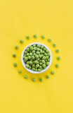 Fototapeta  - Green peas on a bright yellow background. Creative layout with pattern peeled peas. Fun food. Graphic minimal concept.
