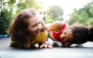 Front view of young teenager girls friends outdoors in garden, laughing.