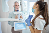 Fototapeta  - Professional dentist looking at her patient getting x-ray