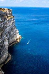 Boat travel in beautiful blue sea with clear water and rocks. Top view motorboat sailing on coastline. Travel and tourism in mediterranean sea. Blue relax landscape