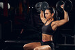 Muscled lady wearing sportswear and lifting weights