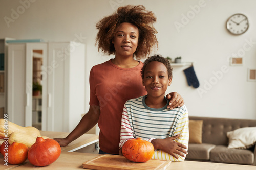 Cuadros en Lienzo Beautiful African American woman and her teen son standing together at table wit