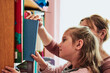 © Przemek Klos - Little girl preschooler choosing a book to read. Child with her mother taking a book from bookshelf